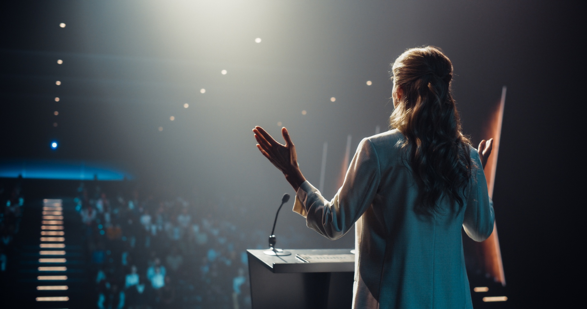 Keynote speaker on a brightly lit conference stage